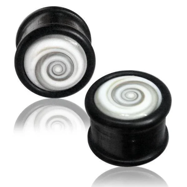 Two black cylindrical Holz Plug Shivaauge plugs with white swirl shell center designs are displayed on a white background, each with a subtle reflection beneath.