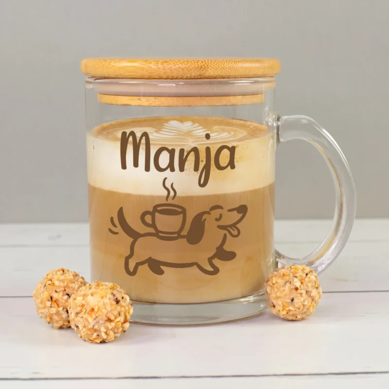 Glastasse mit Bambusdeckel und Namen Manja, gefüllt mit Kaffee und Milchschaum